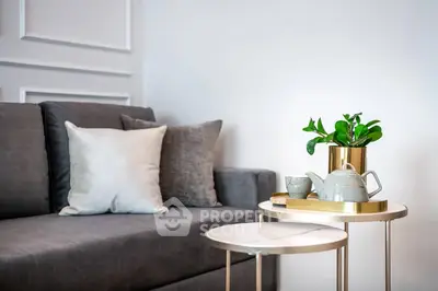 Stylish modern living room with elegant gray sofa and chic side tables, perfect for cozy relaxation.