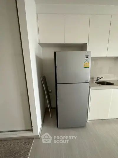 Modern kitchen with sleek stainless steel fridge and minimalist cabinetry