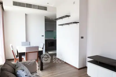 Modern open-plan living and dining area with sleek kitchen in contemporary apartment.