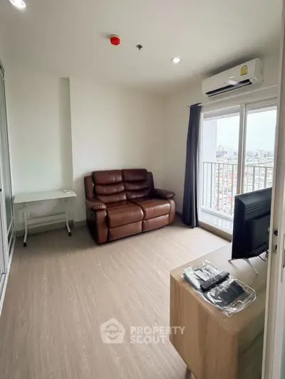 Modern living room with leather sofa, TV, and balcony view in high-rise apartment.