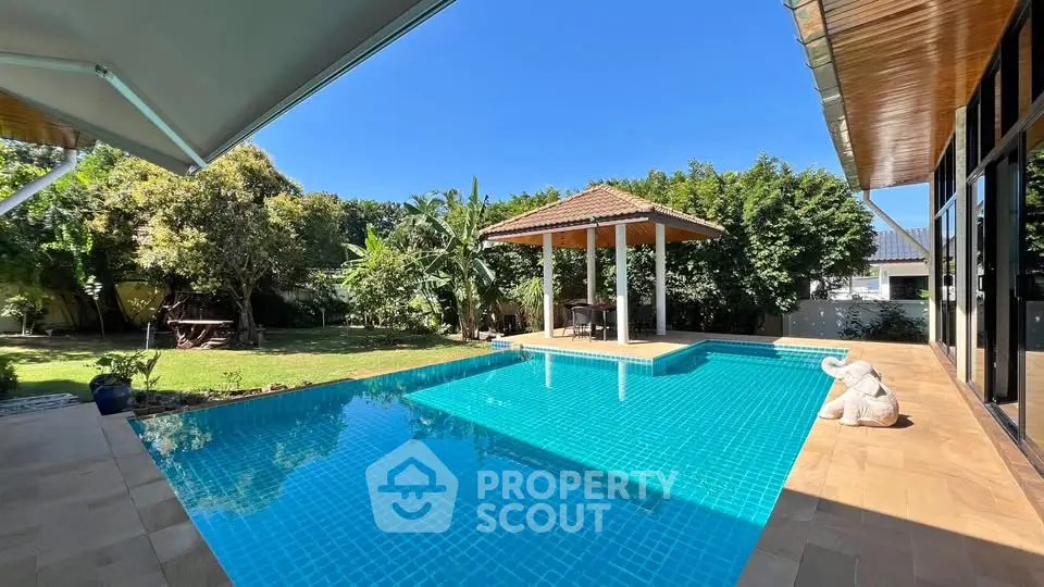 Luxurious backyard with stunning pool and lush garden, perfect for relaxation and entertainment.