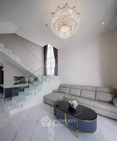 Luxurious living room with elegant chandelier and modern staircase