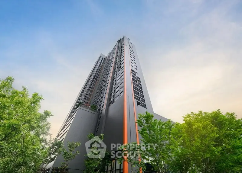 Stunning modern high-rise building with sleek design and lush greenery, perfect for urban living.