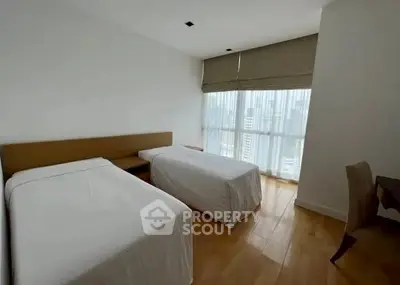 Modern bedroom with twin beds and city view from large window.