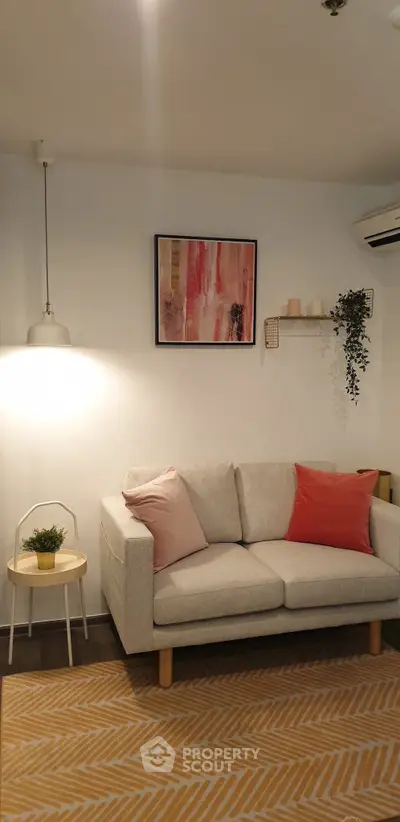 Cozy living room with modern decor, featuring a stylish sofa, wall art, and ambient lighting.