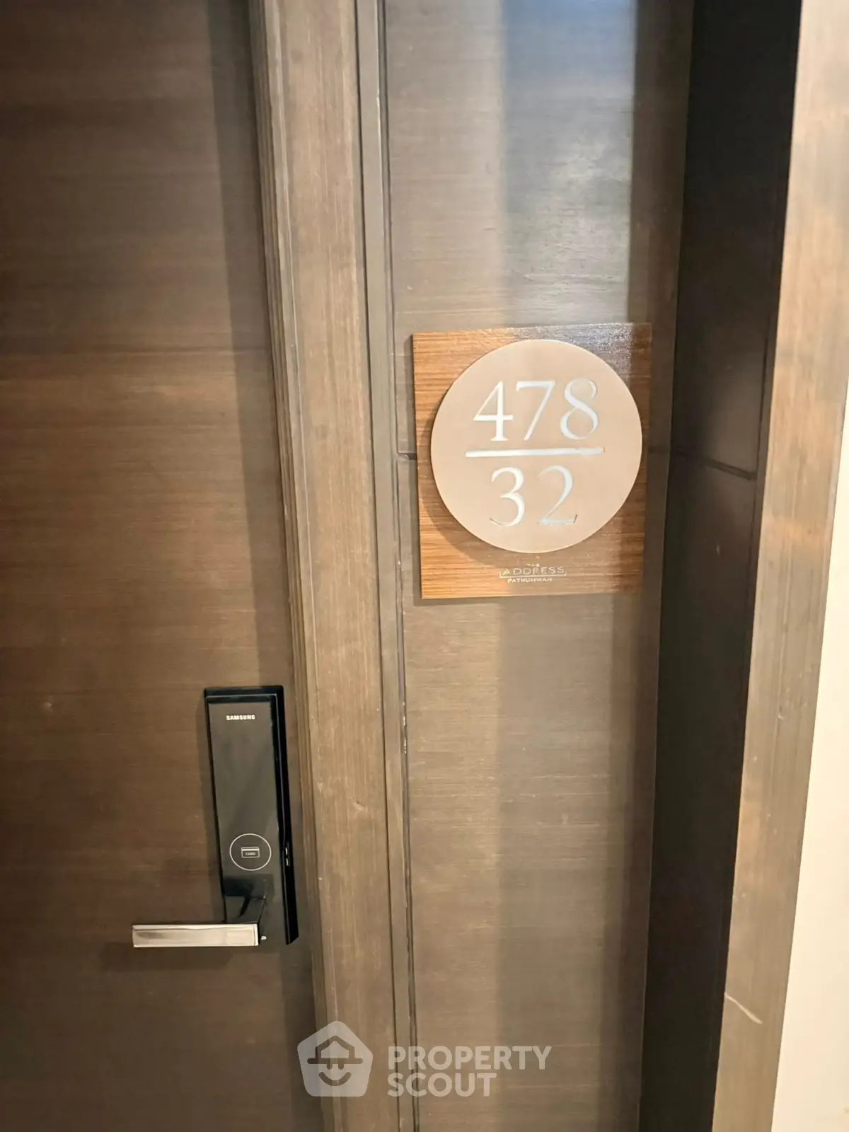 Modern apartment door with digital lock and stylish room number plaque.