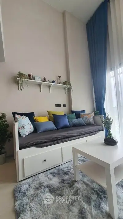 Chic living room with modern decor, plush sofa, vibrant cushions, and elegant curtains, perfect for relaxation.