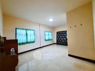 Spacious empty room with tiled floor and green curtains, ideal for customization.