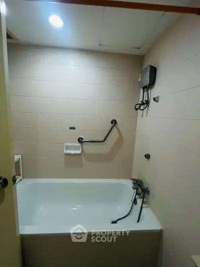 Compact bathroom with bathtub and wall-mounted water heater