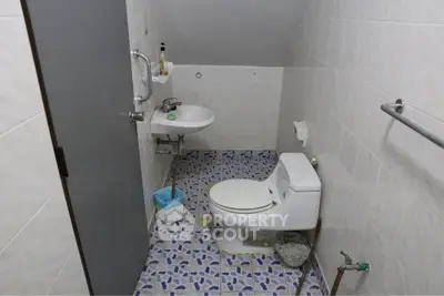 Compact bathroom with modern fixtures and unique tile flooring.