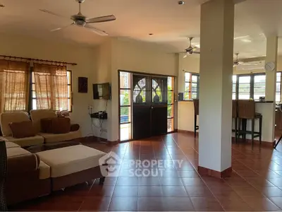 Spacious open-plan living room with modern furnishings and large windows for natural light.