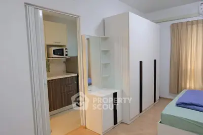 Modern bedroom with adjacent compact kitchen in a cozy apartment setting.