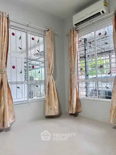 Bright corner room with large windows and air conditioning, perfect for cozy living.