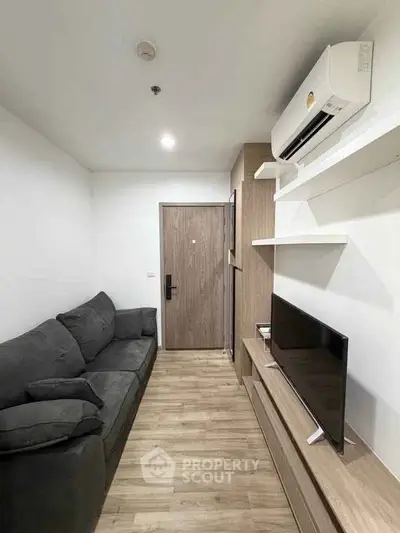 Modern living room with sleek design, featuring a comfortable sofa and wall-mounted TV unit.
