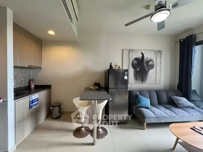 Modern living room with compact kitchen and stylish decor in a cozy apartment.