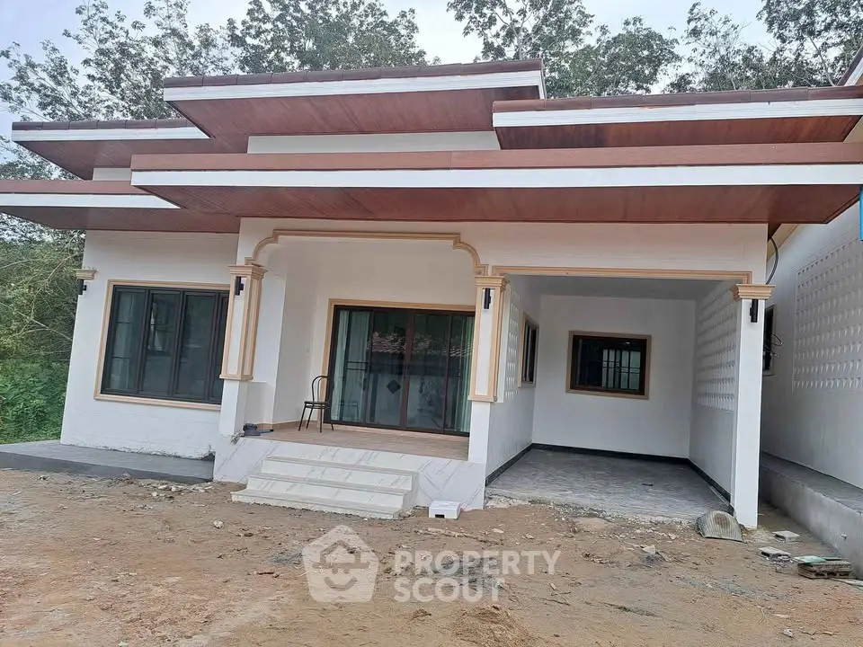 Modern single-story house with unique roof design and spacious front area.