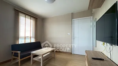 Modern living room with minimalist furniture and wall-mounted TV