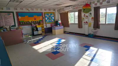 Bright and spacious classroom with colorful decor and large windows.