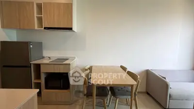 Modern open-layout kitchen and dining area with sleek appliances and cozy seating.