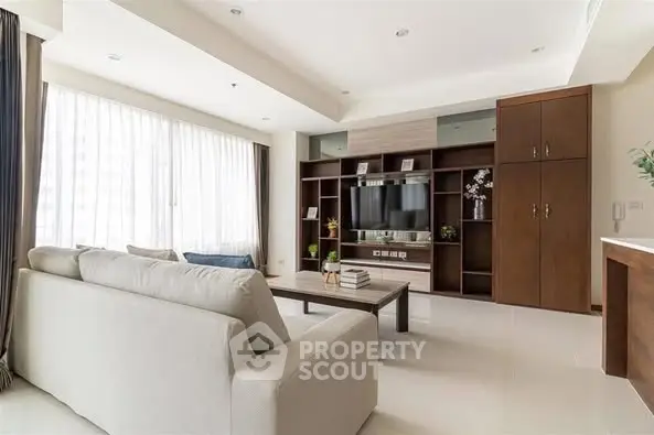 Spacious modern living room with large windows and elegant built-in shelving.