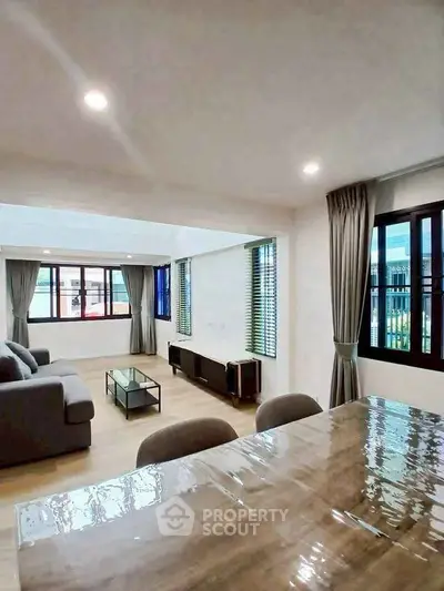 Spacious modern living room with large windows and elegant furnishings