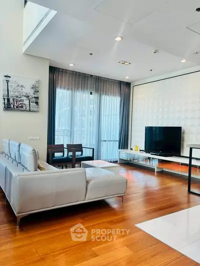 Modern living room with sleek furniture and large windows in a stylish apartment.