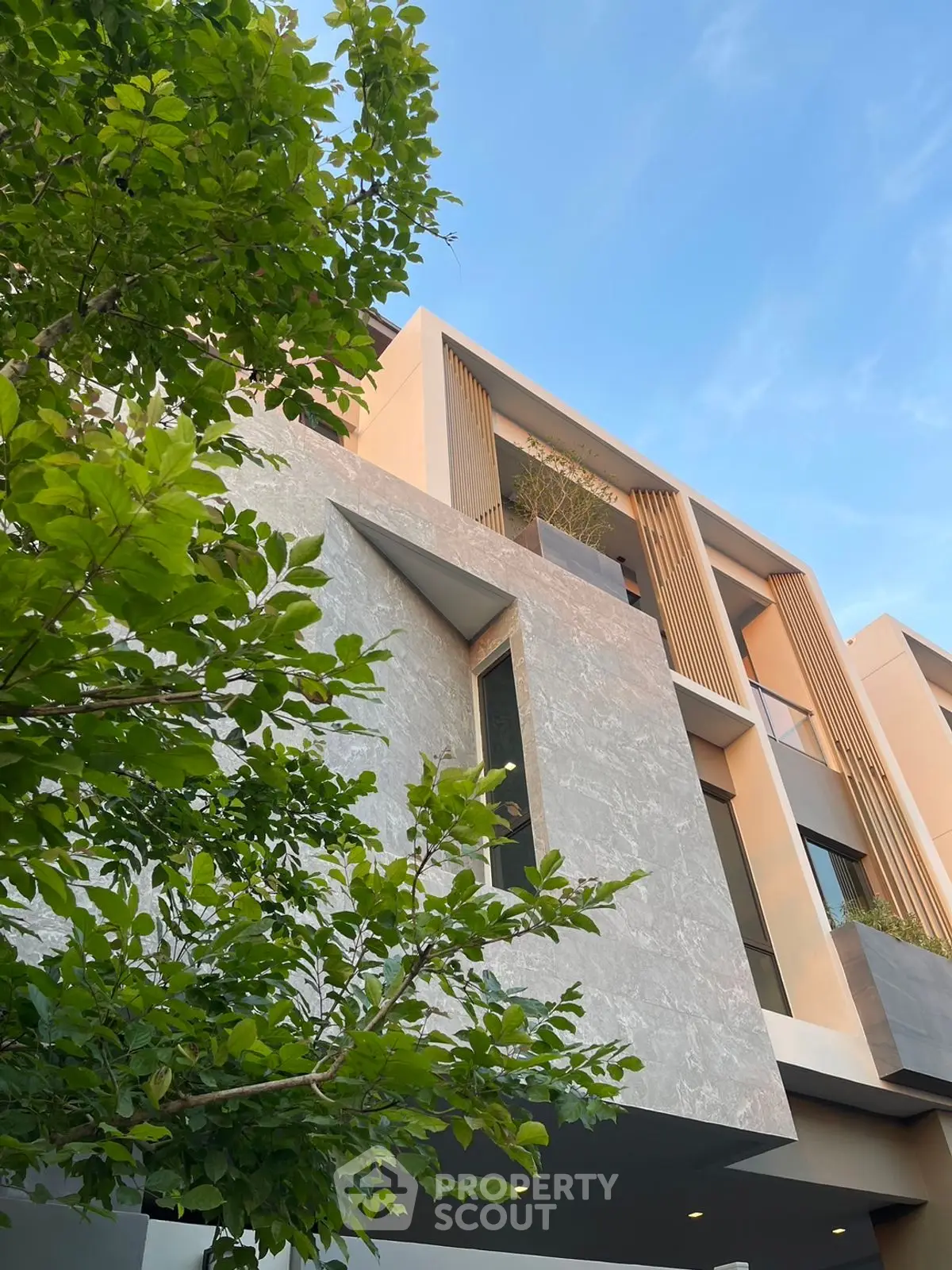 Modern architectural building with sleek design and lush greenery, showcasing contemporary urban living.