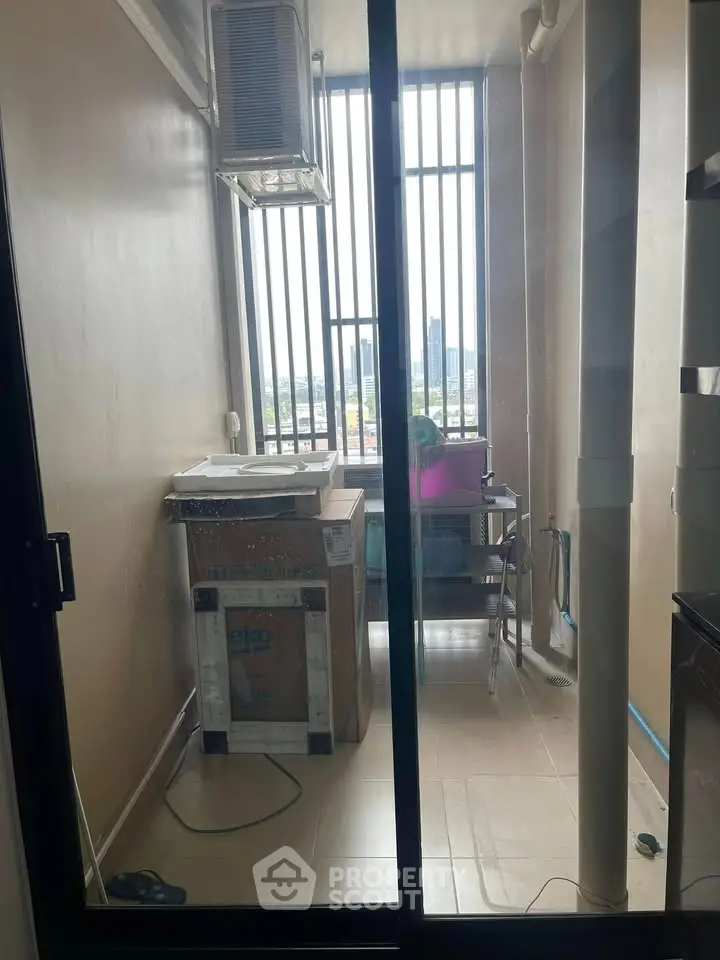 Compact laundry area with washing machine and city view, ideal for urban living.