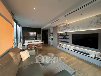 Modern open-plan living room with stylish decor and large TV