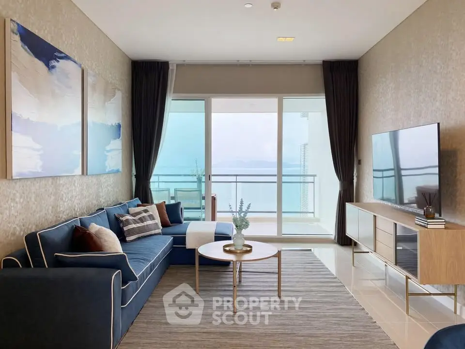 Luxurious living room with stunning ocean view, elegant decor, and spacious balcony access.