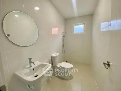 Modern minimalist bathroom with white tiles and round mirror