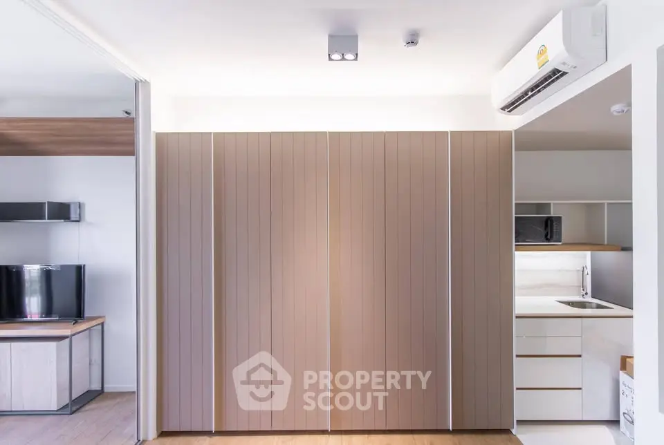 Modern apartment interior with sleek storage and compact kitchen area