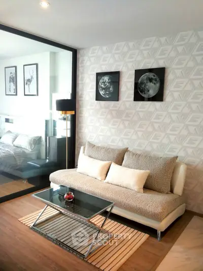 Modern living room with stylish decor and glass partition to bedroom