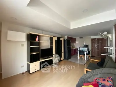 Spacious living room with modern furniture and open kitchen layout, ideal for comfortable living.