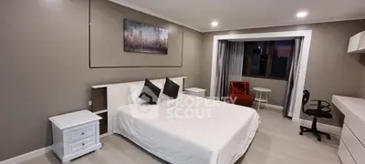 Spacious modern bedroom with elegant decor and city view.