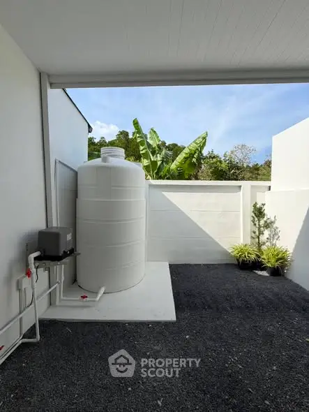 Modern exterior with water tank and lush greenery, perfect for sustainable living.