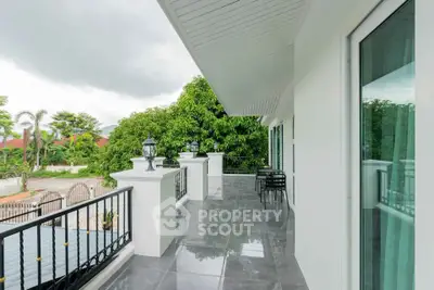 Spacious balcony with elegant railing and lush garden view