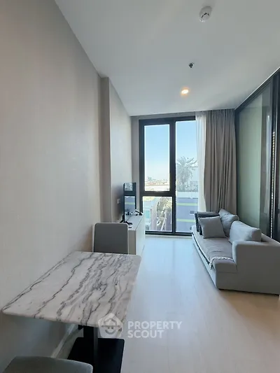 Modern living room with marble table and large window offering city view