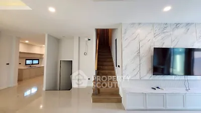 Modern interior with marble accent wall, sleek staircase, and mounted TV in a spacious living area.