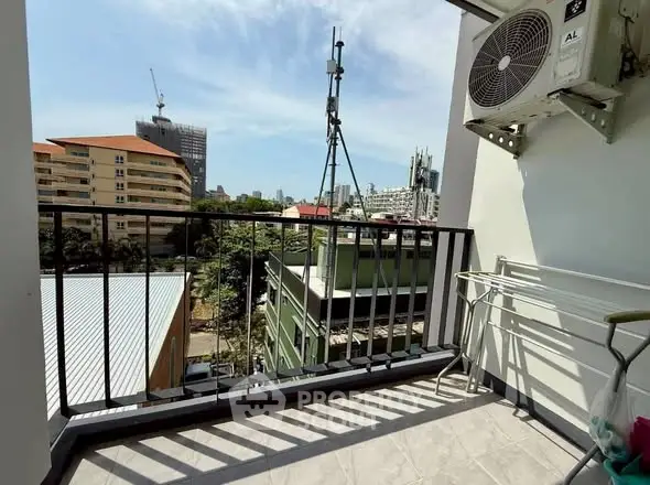 Charming balcony with city view and air conditioning unit, perfect for relaxation.