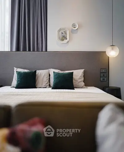 Elegant bedroom with modern decor and plush pillows in a stylish apartment.