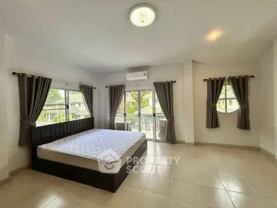 Spacious bedroom with large windows and modern decor in a bright home.