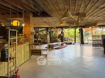 Spacious open-air rustic living area with bamboo decor and natural lighting, perfect for relaxation and gatherings.