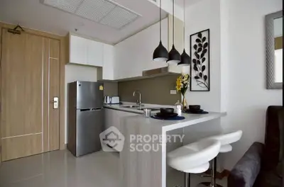 Modern kitchen with sleek design, featuring a breakfast bar and stylish pendant lighting.