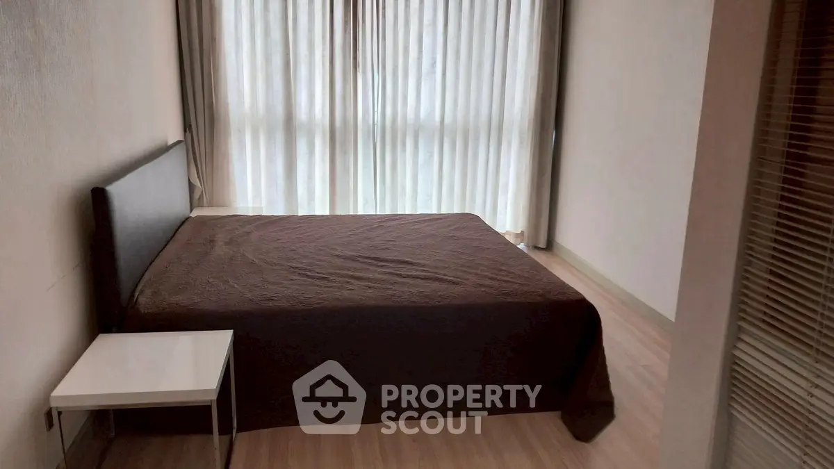 Spacious bedroom with large window and modern furnishings