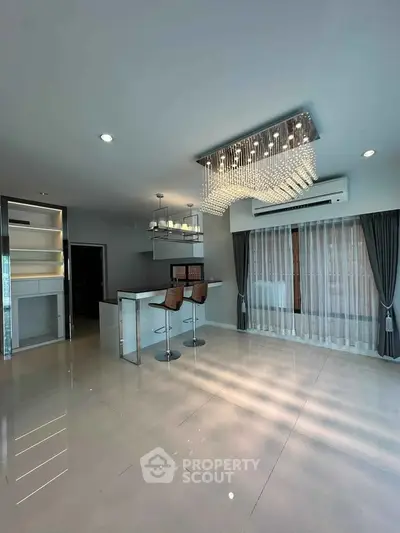 Modern living room with elegant chandelier and open kitchen layout