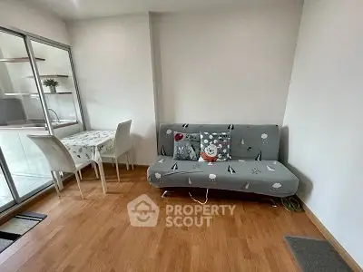 Cozy living room with modern sofa and dining area in open layout apartment.