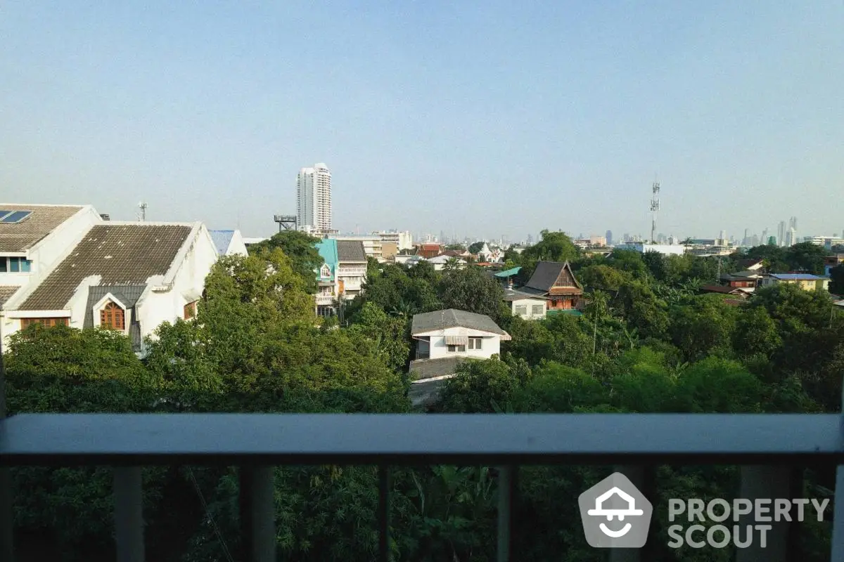 Stunning cityscape view from a balcony overlooking lush greenery and urban skyline.