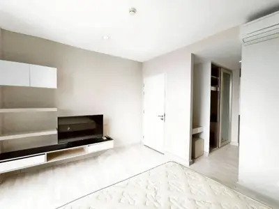 Modern living room with sleek TV unit and minimalist design, featuring neutral tones and ample natural light.