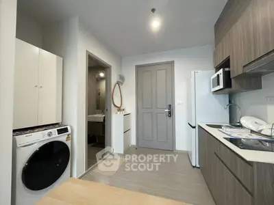 Modern kitchen with sleek appliances and washing machine in stylish apartment